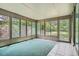 Bright sunroom surrounded by large windows, providing serene views of the outdoor greenery at 4365 Kendall St, Wheat Ridge, CO 80033