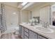 Updated bathroom featuring a double vanity, natural light, and shower with tub at 1655 Hermosa Dr, Highlands Ranch, CO 80126