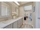 Bright bathroom featuring dual sinks, a large mirror, a window, and hardwood floors at 1655 Hermosa Dr, Highlands Ranch, CO 80126