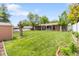 Expansive backyard featuring lush green lawn, mature trees, storage shed, and privacy fence at 2112 S Olathe St, Aurora, CO 80013