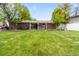 This backyard is very spacious, well-manicured and includes a covered patio, lush lawn, and mature trees at 2112 S Olathe St, Aurora, CO 80013
