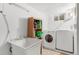 Laundry room with a wash sink, a shelf, a washing machine, and a dryer at 2112 S Olathe St, Aurora, CO 80013
