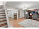 Spacious living room with wood floors, a modern chandelier, a gray rug, and two armchairs at 2112 S Olathe St, Aurora, CO 80013