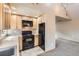 Efficient kitchen with light wood cabinets, black appliances, and adjacent carpeted living area at 579 S Sherman St, Denver, CO 80209