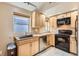 Efficient kitchen with wood cabinets, black appliances, and stainless steel dishwasher at 579 S Sherman St, Denver, CO 80209