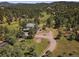 Aerial view of home on large lot with manicured lawn and mature trees at 31518 Niakwa Rd, Evergreen, CO 80439