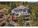 Aerial view features large back deck, manicured landscaping with a walking path and mature trees at 31518 Niakwa Rd, Evergreen, CO 80439