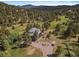 An aerial view of a beautiful home surrounded by lush trees and a scenic landscape at 31518 Niakwa Rd, Evergreen, CO 80439