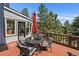 Inviting back deck area with outdoor seating and a red umbrella, perfect for relaxing and entertaining at 31518 Niakwa Rd, Evergreen, CO 80439