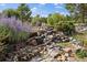Beautifully landscaped rock garden with native plants and a tranquil water feature at 31518 Niakwa Rd, Evergreen, CO 80439