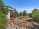 Backyard showcases a well-maintained garden with a foot bridge and a spacious deck at 31518 Niakwa Rd, Evergreen, CO 80439