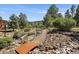 Picturesque backyard with a charming rock garden, walking path, and mature trees at 31518 Niakwa Rd, Evergreen, CO 80439