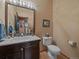 Elegant powder room featuring a marble countertop, modern vanity, and decorative mirror at 31518 Niakwa Rd, Evergreen, CO 80439