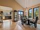 Open dining space leading to outdoor patio with hot tub and an elegant chandelier at 31518 Niakwa Rd, Evergreen, CO 80439