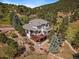 Stunning two-story home featuring a beautiful deck, rock garden, and mature trees at 31518 Niakwa Rd, Evergreen, CO 80439