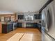 Well-lit kitchen featuring stainless steel appliances, dark cabinets, and hardwood floors at 31518 Niakwa Rd, Evergreen, CO 80439