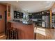 Open kitchen with breakfast bar, stylish dark cabinets, stainless appliances, and hardwood floors at 31518 Niakwa Rd, Evergreen, CO 80439