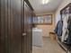 Laundry room featuring dark wood cabinets and a front load washing machine at 31518 Niakwa Rd, Evergreen, CO 80439