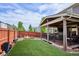 Spacious backyard with artificial turf, a fire pit, and a covered patio for outdoor relaxation and activities at 10397 Helsinki St, Parker, CO 80134