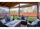 Relaxing covered patio featuring comfortable seating and a serene view of the backyard and trampoline at 10397 Helsinki St, Parker, CO 80134