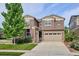 Two-story home with a two-car garage, stone accents, manicured lawn, and basketball hoop at 10397 Helsinki St, Parker, CO 80134