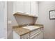 Laundry room with granite countertops and white cabinets for extra storage at 10397 Helsinki St, Parker, CO 80134