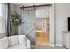 Stylish bathroom with a sliding barn door, a soaking tub, and modern fixtures for a spa-like experience at 10397 Helsinki St, Parker, CO 80134