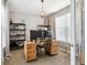 Home office with a wooden desk, shelves, a large window and neutral-colored walls at 10397 Helsinki St, Parker, CO 80134