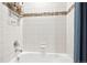 Bright white tiled shower and tub with modern fixtures and decorative accent tile at 10397 Helsinki St, Parker, CO 80134