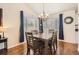 Bright dining room with hardwood floors, a wooden table, and blue curtains at 10491 Tiger Run, Lone Tree, CO 80124