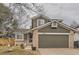 Two-story house with a brick and siding exterior, attached garage, and landscaped yard at 10491 Tiger Run, Lone Tree, CO 80124