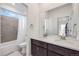 Bright bathroom featuring double sinks, a tub with a shower, a large mirror, and neutral finishes at 15624 W Floyd Dr, Morrison, CO 80465