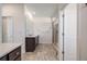 Bathroom featuring a glass-enclosed shower, large mirror, dark cabinets, and a gray patterned tile floor at 15624 W Floyd Dr, Morrison, CO 80465