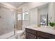 Bathroom featuring tile shower with glass door, single sink vanity, and window at 15624 W Floyd Dr, Morrison, CO 80465