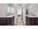 Bathroom showcasing double vanity sinks, sleek countertops, tiled floors, and a view into the main bedroom at 15624 W Floyd Dr, Morrison, CO 80465