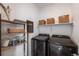 Functional laundry room with shelving, storage baskets, and modern washer/dryer at 15624 W Floyd Dr, Morrison, CO 80465