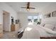 Bright main bedroom with a ceiling fan, plush bedding, and natural light from the large windows at 15624 W Floyd Dr, Morrison, CO 80465