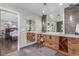 Stylish bathroom boasting a stone accent wall, wood cabinets, and open doorway to bedroom at 5727 Colorow Dr, Morrison, CO 80465