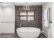 Modern bathroom with a freestanding tub and a decorative stone wall at 5727 Colorow Dr, Morrison, CO 80465