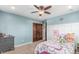 Charming bedroom with blue walls, a ceiling fan, and unique decor elements, plus dark wood doors at 5727 Colorow Dr, Morrison, CO 80465