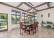This dining room features wood beams, tile floors, and windows overlooking the mountains and pool at 5727 Colorow Dr, Morrison, CO 80465