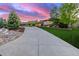 Long driveway leading to a beautifully landscaped home with mature trees and lush lawn at 5727 Colorow Dr, Morrison, CO 80465
