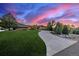 A beautiful home with a long, curved driveway and well-maintained lawn under a vibrant twilight sky at 5727 Colorow Dr, Morrison, CO 80465