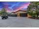 Detached garage with attractive wood doors, surrounded by green trees and a golf cart on the driveway at 5727 Colorow Dr, Morrison, CO 80465