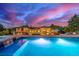 Stunning pool with integrated waterfall feature, deck area, and beautiful views of the estate at sunset at 5727 Colorow Dr, Morrison, CO 80465