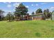 Spacious backyard featuring a well-maintained lawn and a charming home with stone and green siding at 30651 Hollings Way, Golden, CO 80403