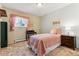 Bright bedroom with pink accents, a cozy bed, and a window with charming curtains at 30651 Hollings Way, Golden, CO 80403