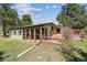 Home exterior featuring a sunroom, a wooden deck, and surrounded by a lush, green lawn at 30651 Hollings Way, Golden, CO 80403