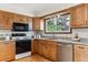 Modern kitchen featuring granite countertops, stainless steel appliances, hardwood floors, and a large window at 30651 Hollings Way, Golden, CO 80403