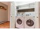 Laundry room featuring washer, dryer, storage shelves, and hardwood floors at 30651 Hollings Way, Golden, CO 80403